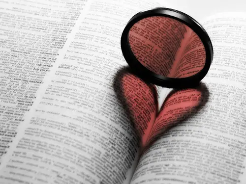 Image "An open book with a magnifying glass on it, creating the shape of a heart" (1954x1466)