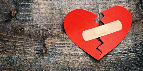Image "A broken heart sealed with a Band-aid on a wooden background" (4000x2000)